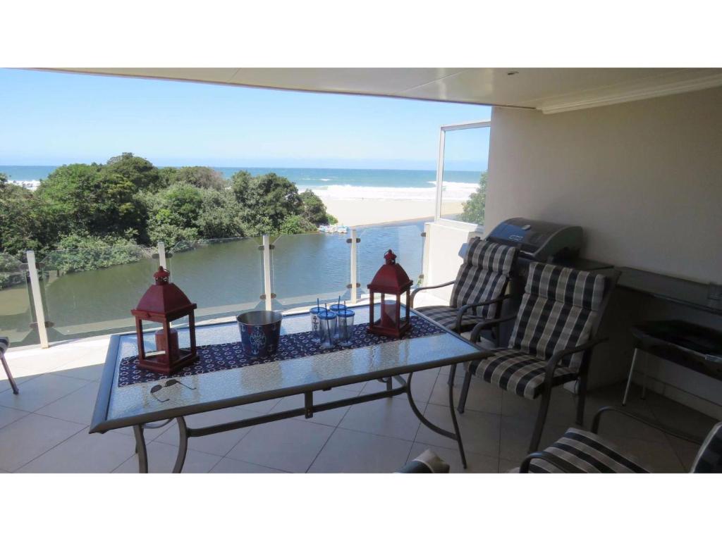 a balcony with a table and chairs and a view of the ocean at Arabella No. 5 in Margate