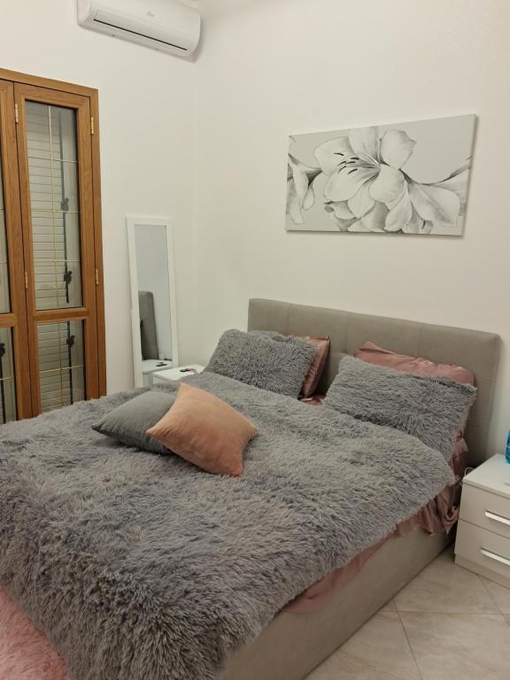 Una cama con dos almohadas encima en un dormitorio. en B&b Mythos, en Tuglie