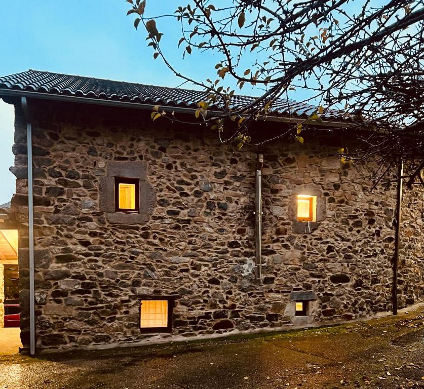 a stone building with two windows with lights in it at Casa Solle - Bonita casa de montaña a 20 min de San Isidro 