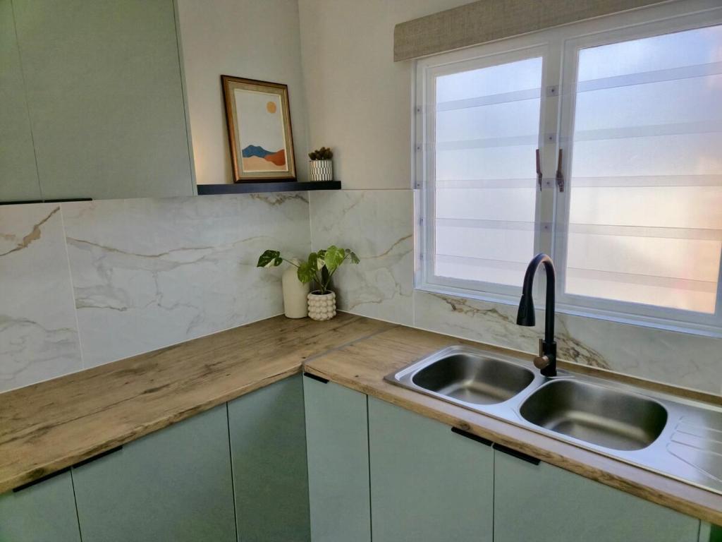 een keuken met een spoelbak en een raam bij Sand & Sea Studio Hermanus in Hermanus