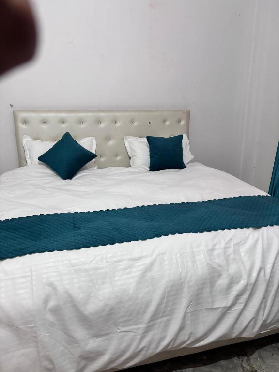 a bed with blue and white sheets and pillows at R D Palace and Resort in Bhauli