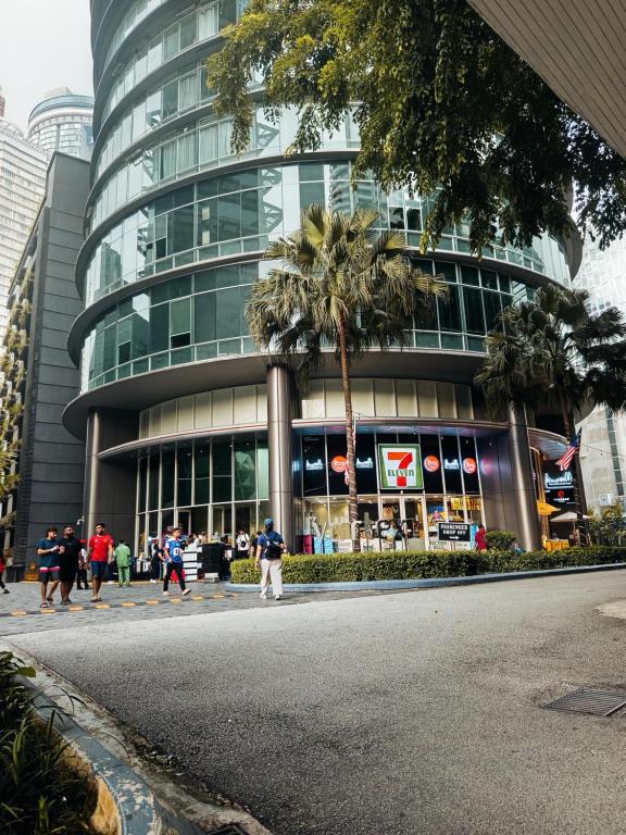 gente caminando por una calle frente a un edificio en Vortex klcc by AzlanAdiyan, en Kuala Lumpur