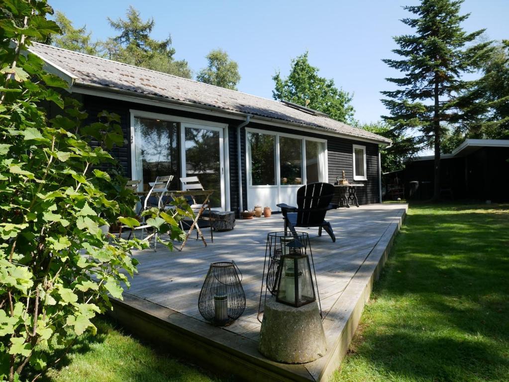 a wooden deck with chairs and a house at Summerhouse in Ulvshale, Møn in Stege