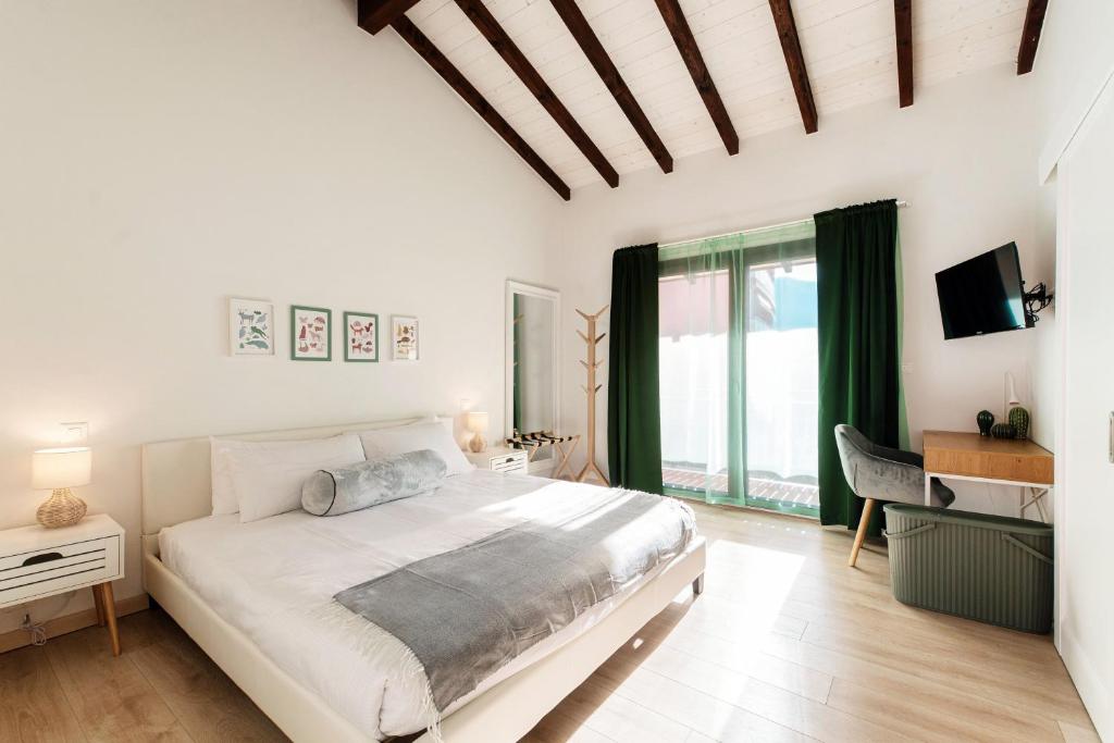 une chambre blanche avec un grand lit et une fenêtre dans l'établissement Florida Ascona Rooms by Quokka 360 - Close to Lake and City, à Ascona