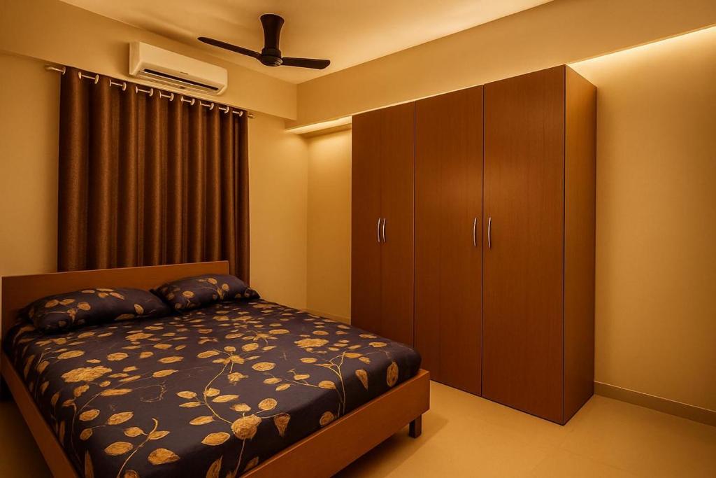 Bhakti Bliss Homestay - Spacious 2bhk AC Apartment near Padmavati Ammavari Temple in Tirupati في تيروباتي: غرفة نوم مع سرير وخزانة كبيرة