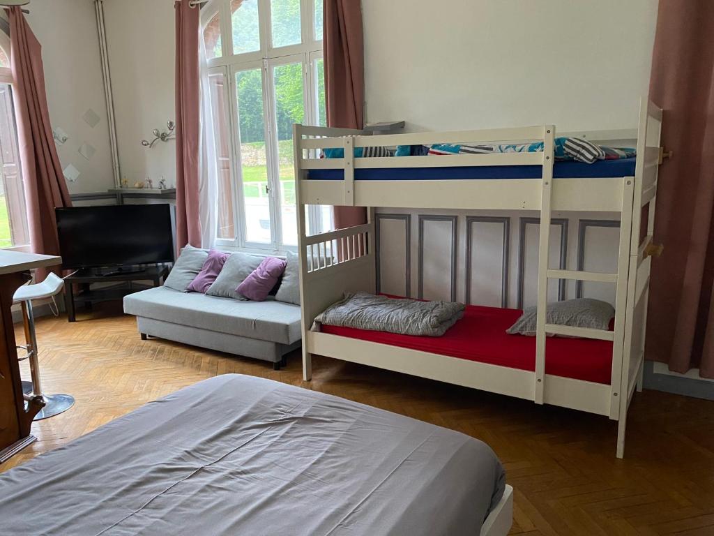 Chateau Gruchet Le Valasse في Gruchet-le-Valasse: غرفة نوم مع سريرين بطابقين وأريكة