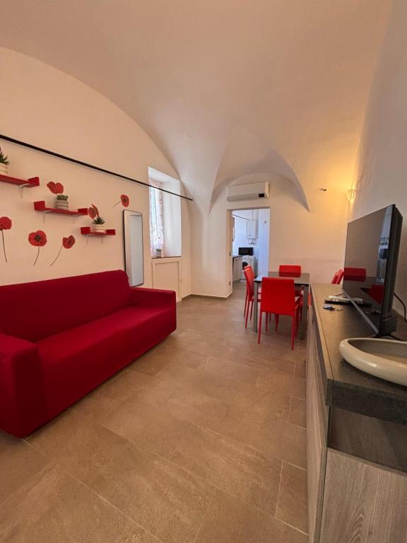 a living room with a red couch and a table at Chez Gabry in Sanremo