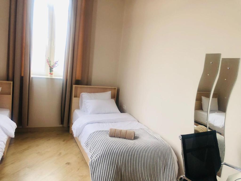 a small room with two beds and a window at Miassine Boutique Hotel in Gyumri