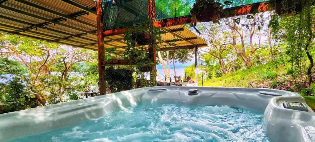 a jacuzzi tub in a garden with trees at Teak house in a forest above the beach 