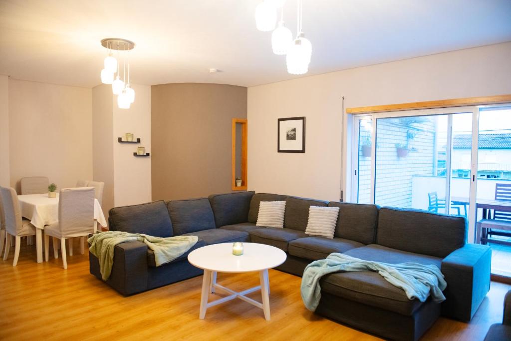 a living room with a blue couch and a table at Meio Mundo in Várzea