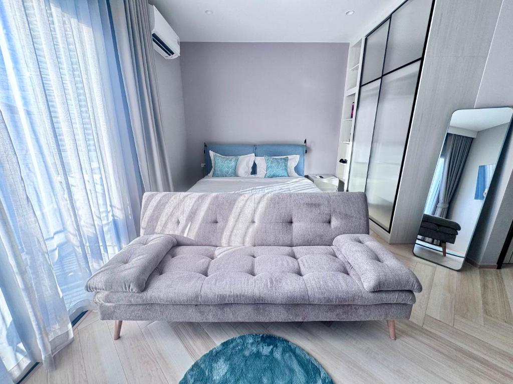 a bedroom with a couch in front of a bed at Title Ledgendary 7th Floor in Bang Tao Beach