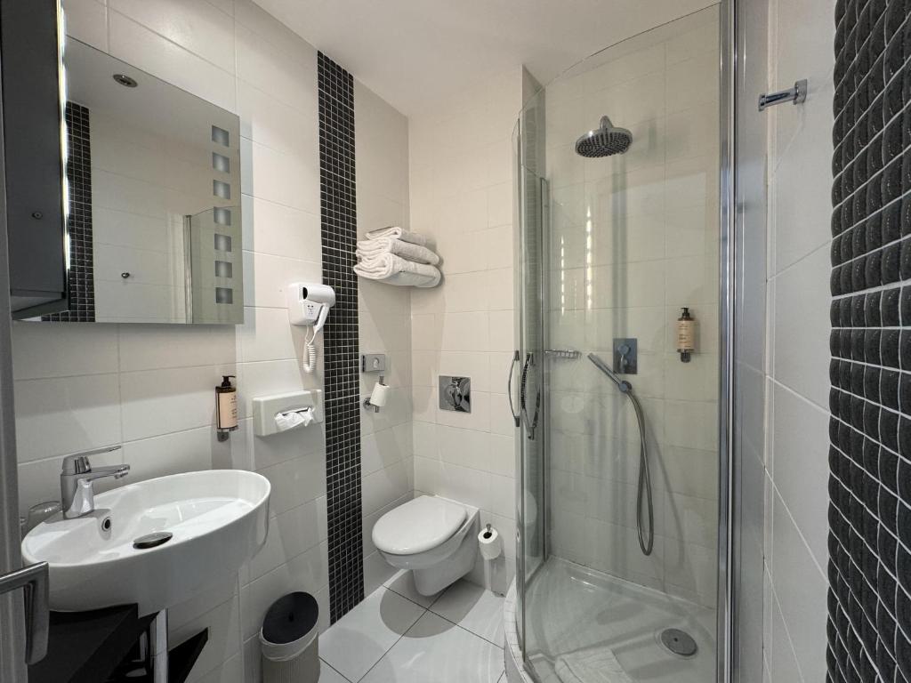 Un baño con inodoro, lavabo y ducha. en Best Western Blois Château, en Blois