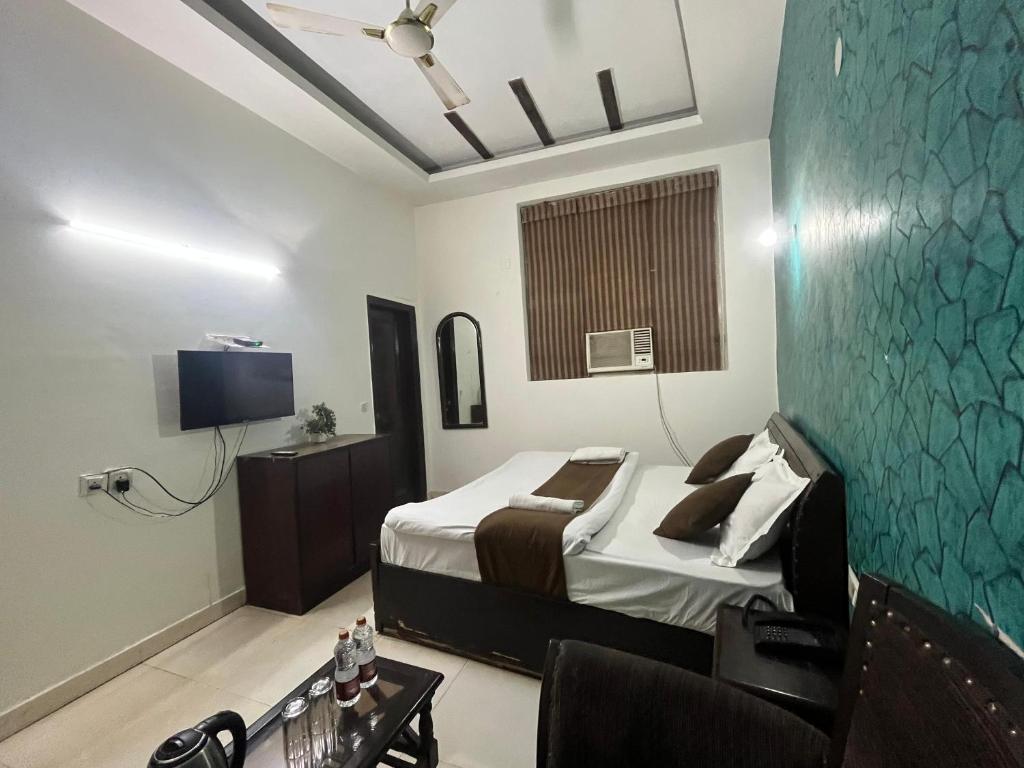 Hotel RS international Couple Friendly في نيودلهي: غرفة فندق مع سرير وتلفزيون