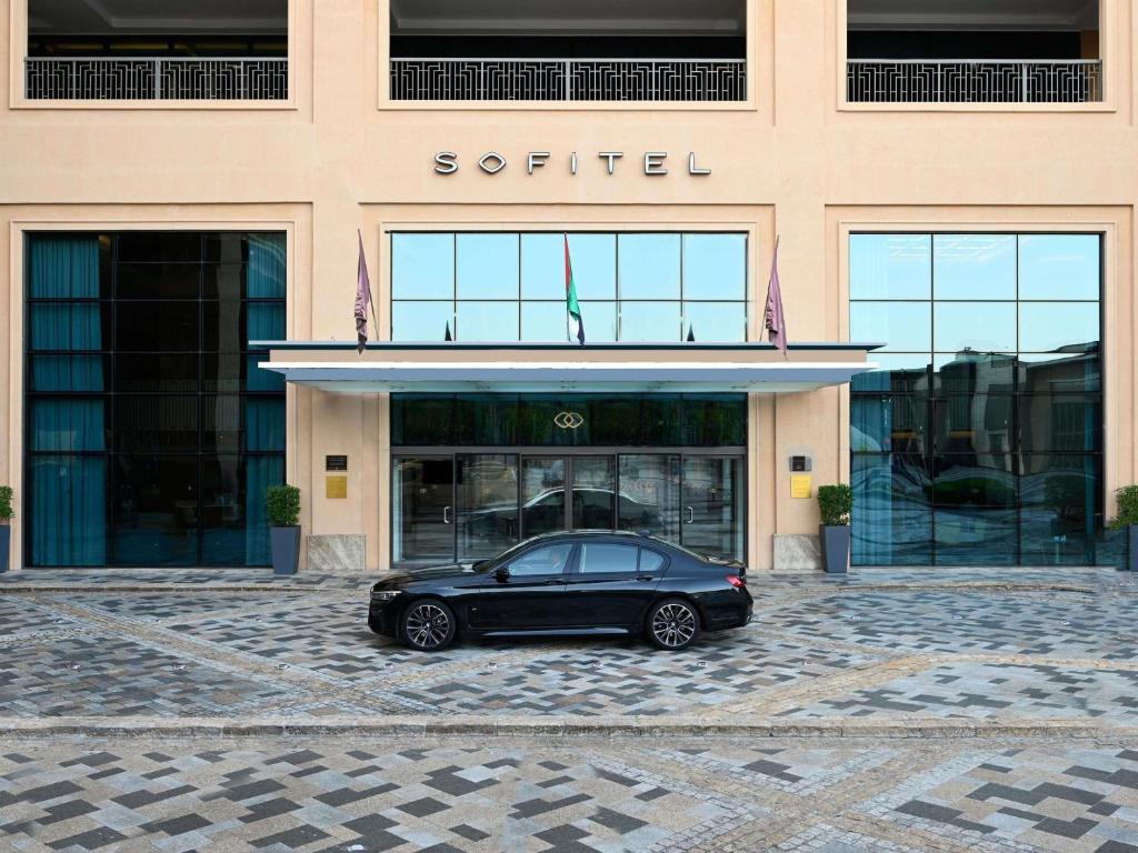 a black car parked in front of a building at Sofitel Dubai Jumeirah Beach in Dubai