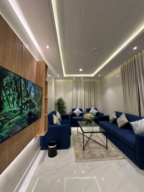 a living room with a blue couch and a tv at شقق نطوان المفروشة in Abha