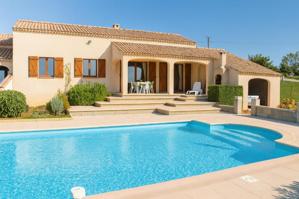 una villa con piscina di fronte a una casa di Gîte le Platane a Montagnac