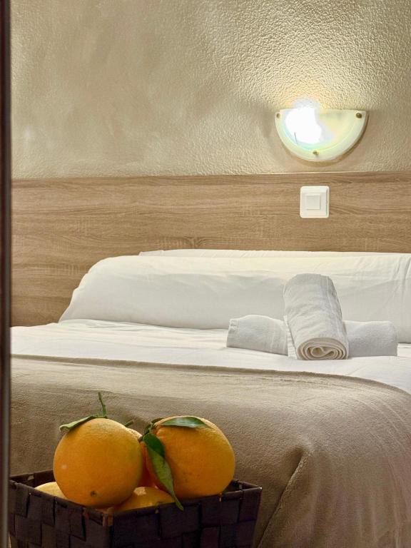 two oranges in a basket next to a bed at HS Altet Suites - Alicante Airport in El Alted