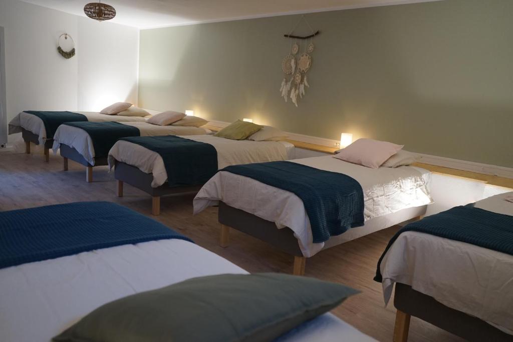 un grupo de cuatro camas en una habitación en Clos du Régrillon, en Pélussin