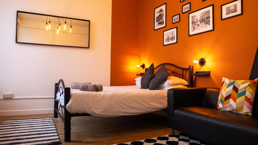 une chambre avec un lit, un canapé et un miroir dans l'établissement NEWLY Refurbed - Large Studio Apt With Private Parking, à Exeter