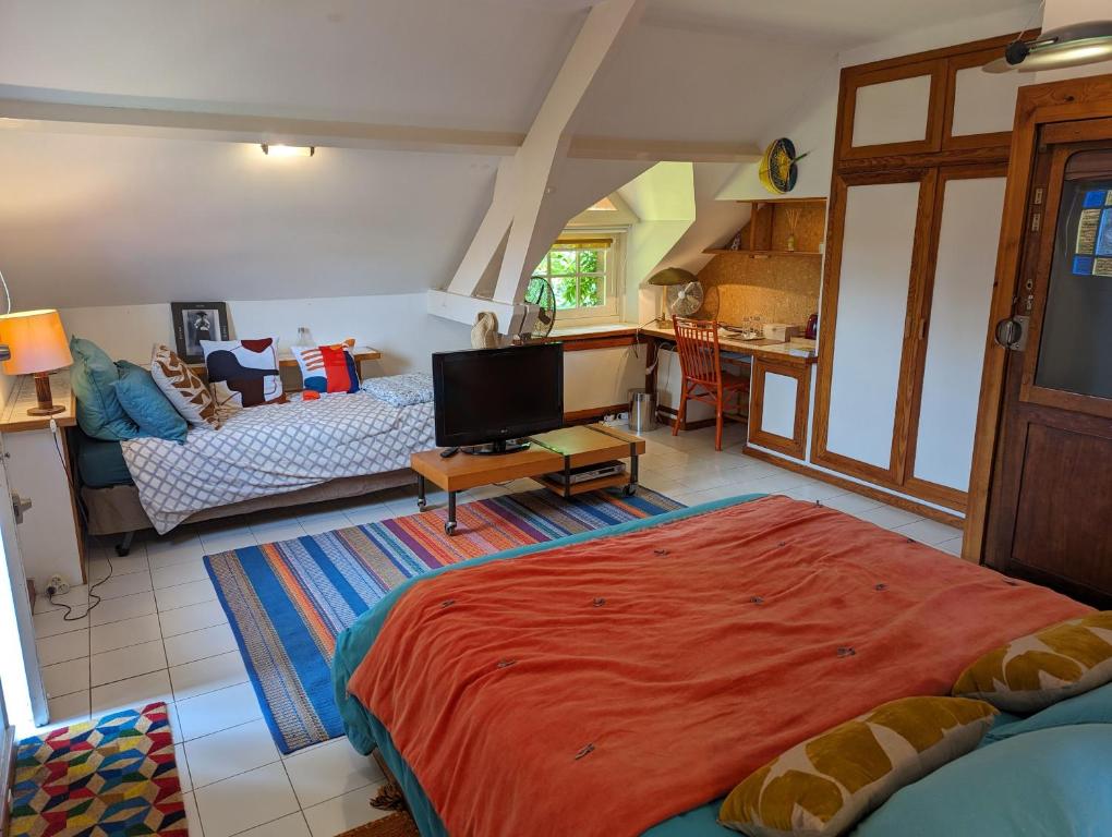 a bedroom with a large bed and a living room at Chambre 3, Le clos du Ru in Presnoy