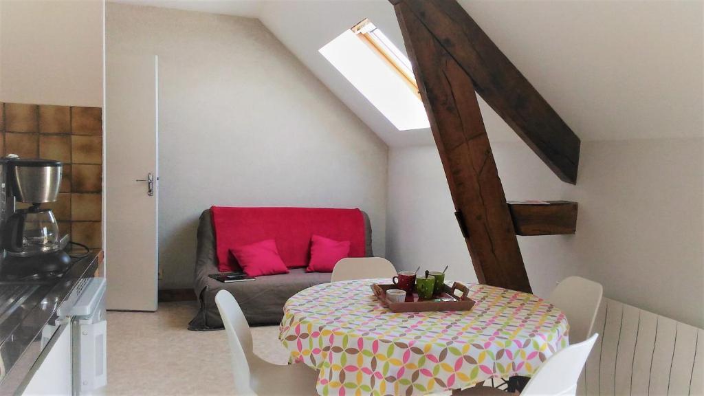 a room with a table and a couch with a red chair at "Chambre 2", Ferme de la Volière in Gidy