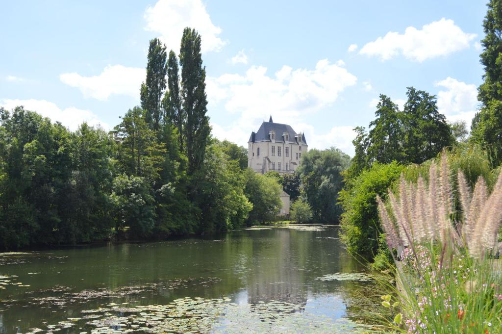 een uitzicht op een rivier met een gebouw op de achtergrond bij Château Raoul in Châteauroux