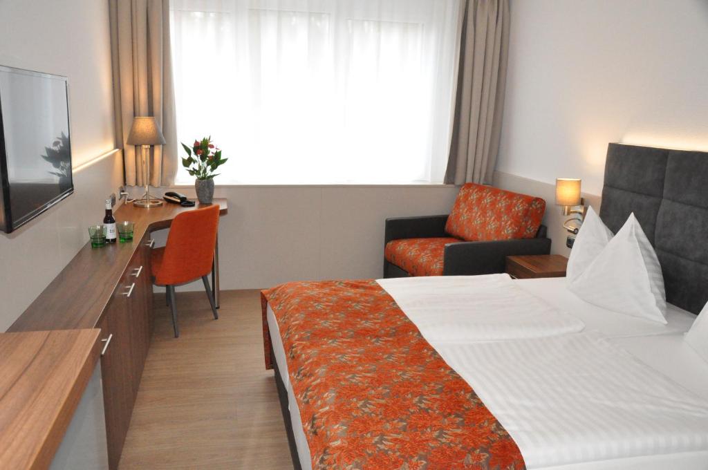 Postel nebo postele na pokoji v ubytování Stadtoase Kolping Hotel