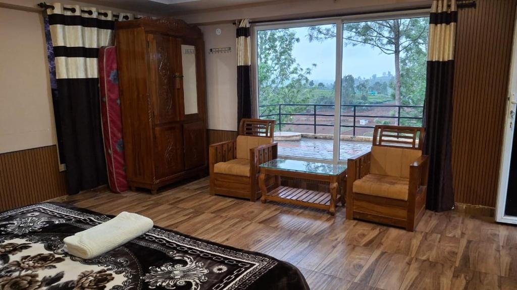 a room with a bed and a table and a window at Greenary homestay in Ooty