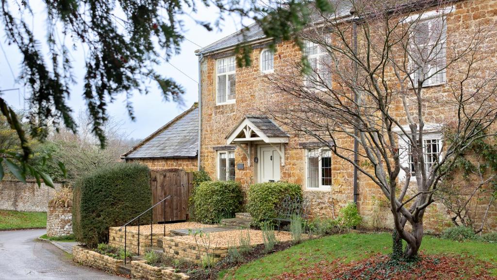 een stenen huis met een hek ervoor bij Oak Cottage in Swerford
