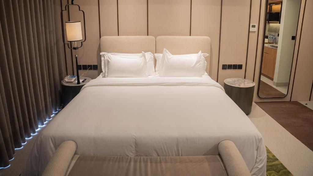 a large white bed in a hotel room at Myze Hotel Waingapu in Waingapu