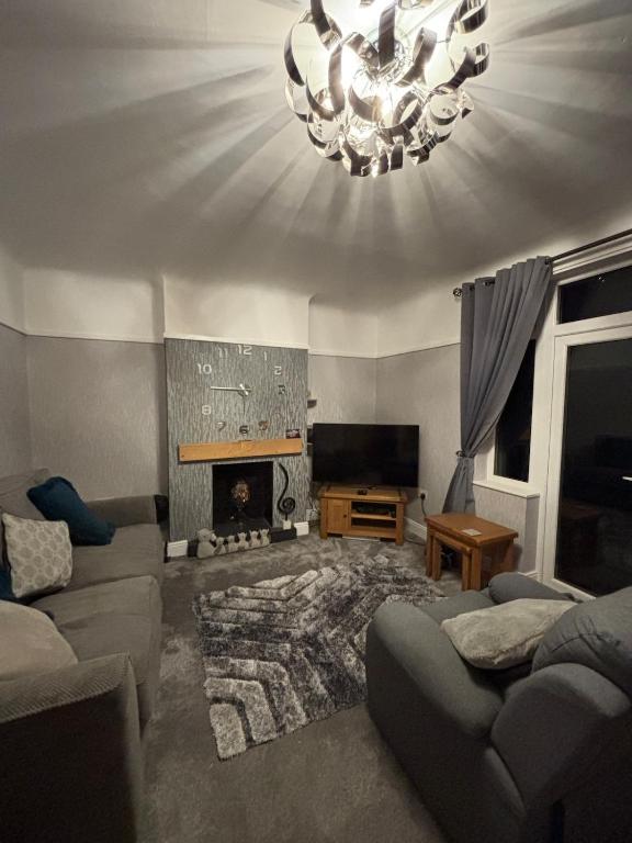 a living room with a couch and a fireplace at Entire House, Parking, Facilities, sleeps up to 6, suitable for contractors, families or NHS in Liverpool