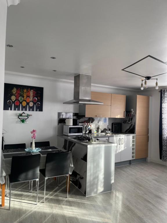 a kitchen with a table and chairs in a room at Bowery Apartment - 2 Bedrooms 1st floor in Dagenham