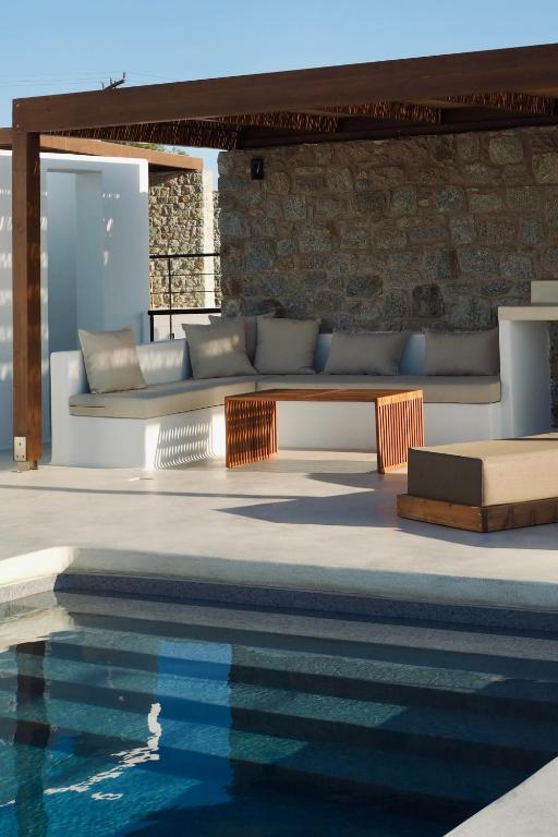 a living room with a couch and a swimming pool at Ayana in Naxos Chora