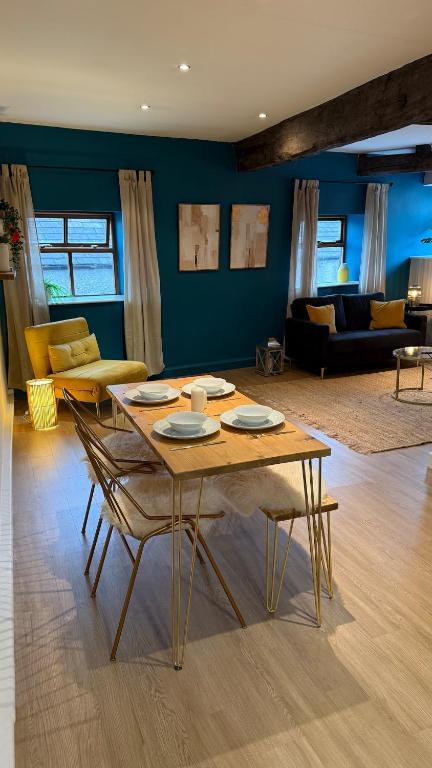 a living room with a wooden table and chairs at Victoria Boutique Apartment in Skipton
