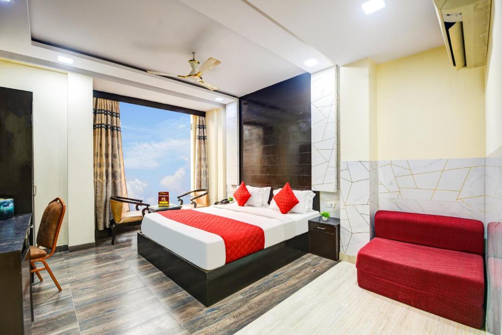 Un dormitorio con una cama y un sofá rojo. en Hotel Kings Inn, Karol Bagh, New Delhi, en Nueva Delhi