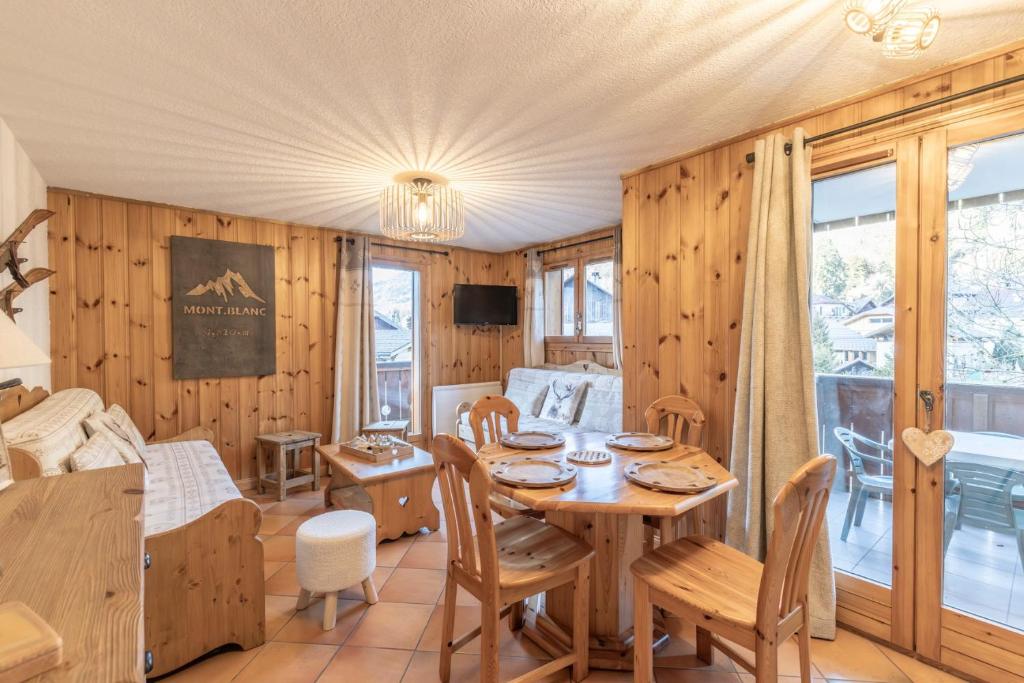 ein Esszimmer mit Holzwänden sowie einem Tisch und Stühlen in der Unterkunft Samoëns à Pied – Appt 4 pers in Samoëns