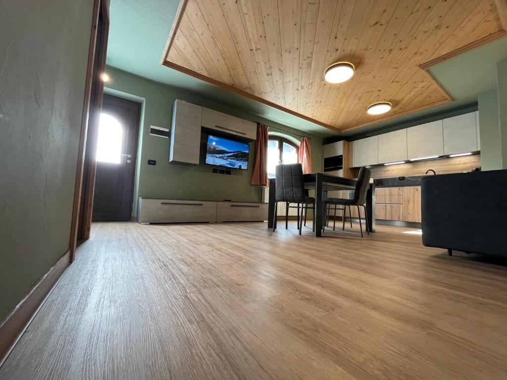Una gran sala de estar con mesa y sillas. en Bait da Nicolin - Myholidaylivigno, en Livigno