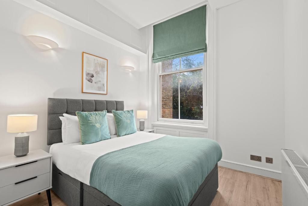 a bedroom with a bed and a window at Kensington Prime Apartments in London
