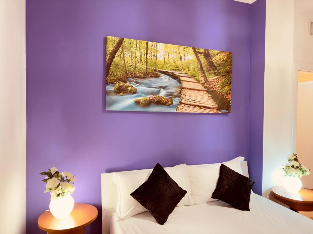 ヴェネツィアにあるLeone Di San Marcoのベッドと壁に絵が飾られた部屋