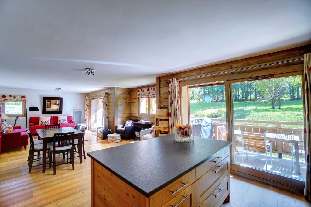 a kitchen and living room with a view of a yard at Hameaux du glaciers in Les Houches