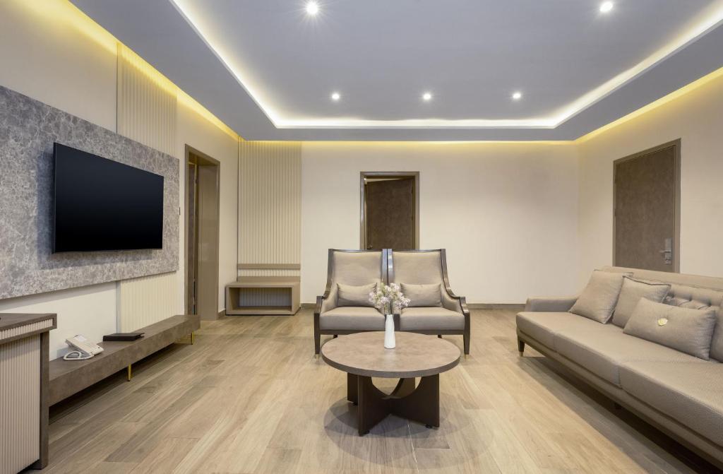 a living room with a couch and a tv at CheckInn Garki, Abuja in Abuja