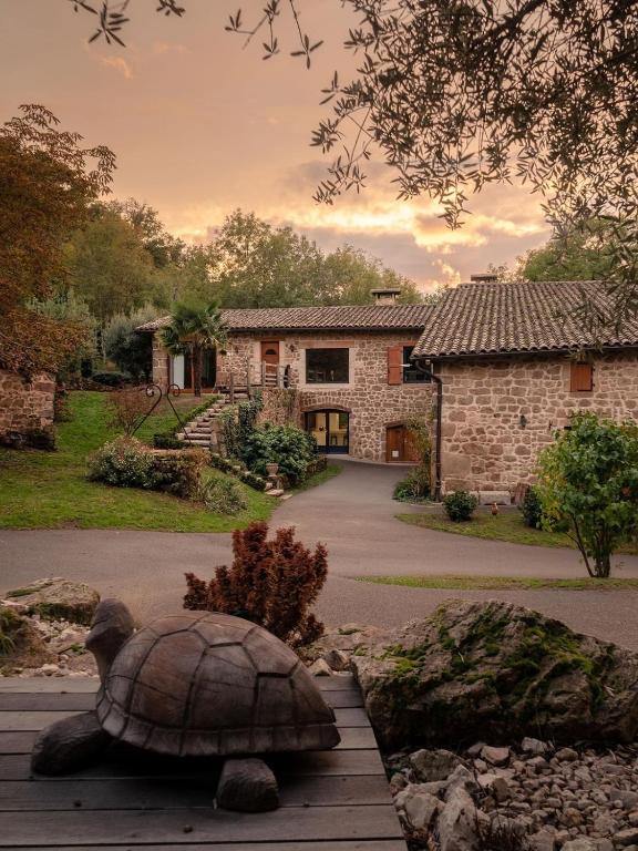 a turtle statue in front of a stone house at Clos du Régrillon in Pélussin