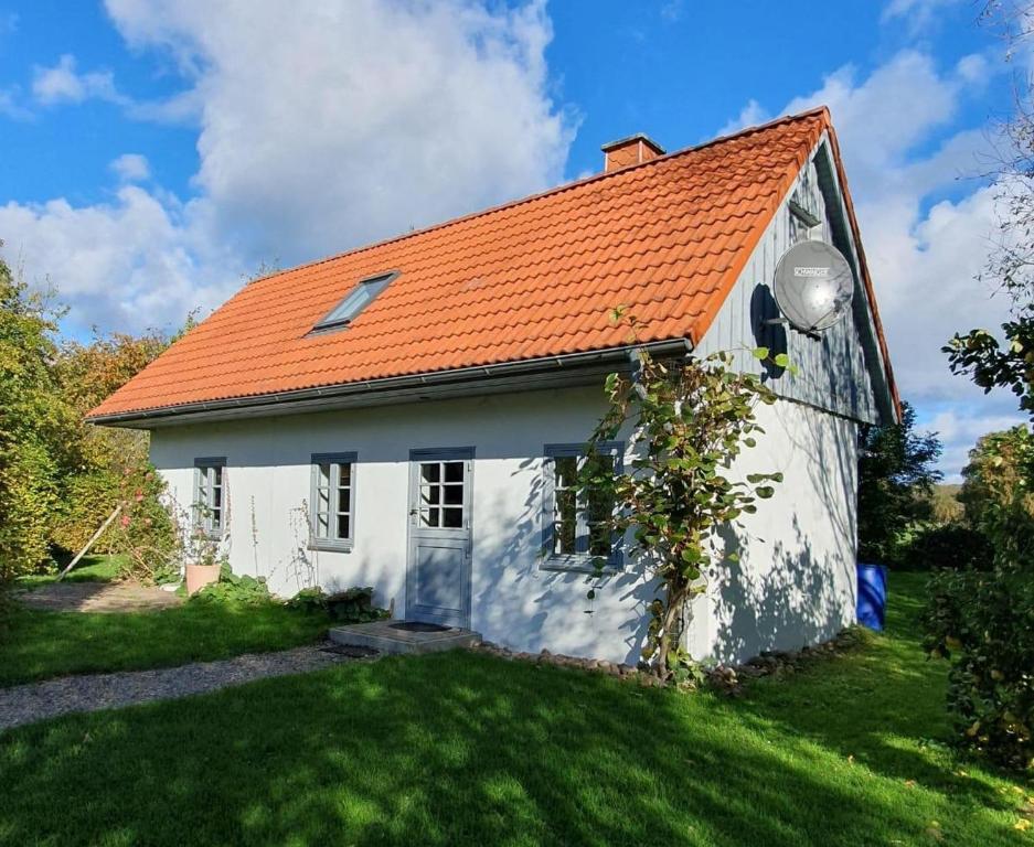 a small white house with an orange roof at Kembser Kate - Ostholstein - NEU! in Behrensdorf