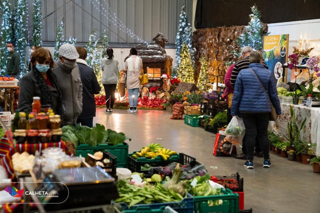 un gruppo di persone che camminano intorno a un mercato con prodotti di Casa de Prazeres a Prazeres