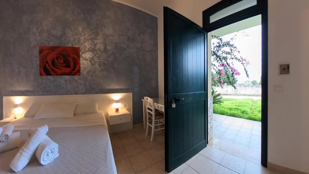 een slaapkamer met een bed met een rode roos aan de muur bij La Carcara in Otranto