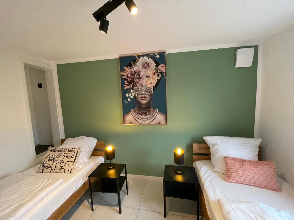 a bedroom with two beds and a painting on the wall at Premium-Apartment, 4 Betten, Nahe Ulm für Familien und Gruppen,Hund in Blaustein