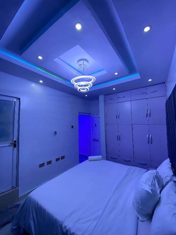 Habitación con cama con techo azul en Fola Homes, en Suru Lere