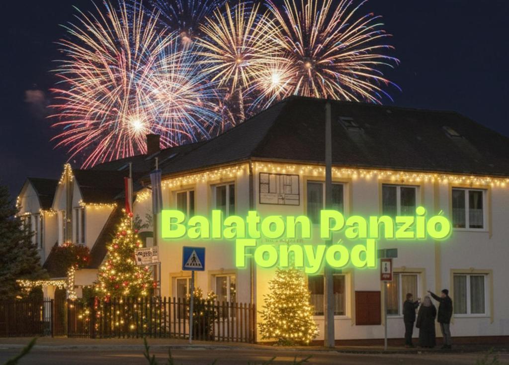 Balaton Panzió في فونيود: مبنى مع ألعاب نارية في الخلفية مع مبنى