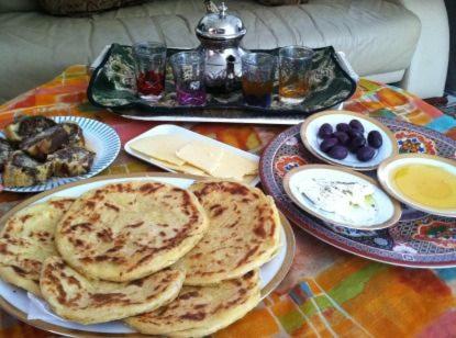 una mesa cubierta con platos de tortitas y otros alimentos en Auberge panorama, en Kasba des Aït Athmane