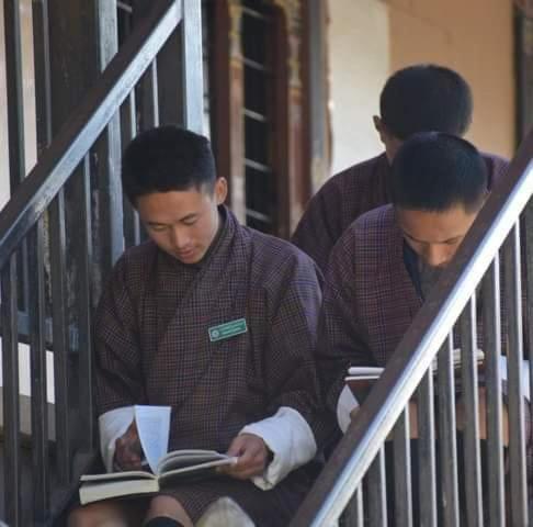 Aja Village Resort في بارو: رجلان يجلسان على الدرج يقرآن كتاباً